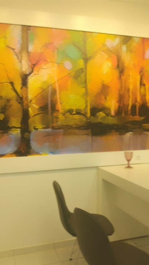 Sala com quadro de floresta outonal e bancada branca